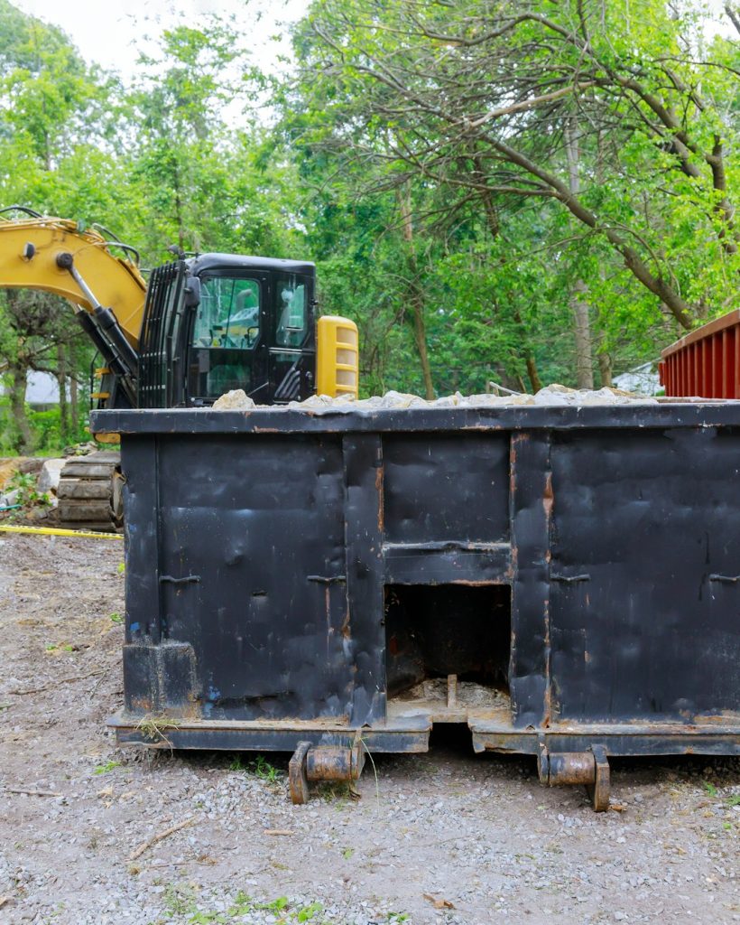 Industrial dumpster filled loaded rubbish removal container renovation building on house under